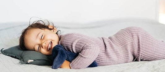 Toddler in merino sleepwear resting on a pillow